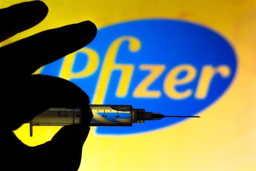 November 11, 2020, Brazil. In this photo illustration the medical syringe (coronavirus vaccine) is seen with Pfizer company logo displayed on a screen in the background — Stock Editorial Photography