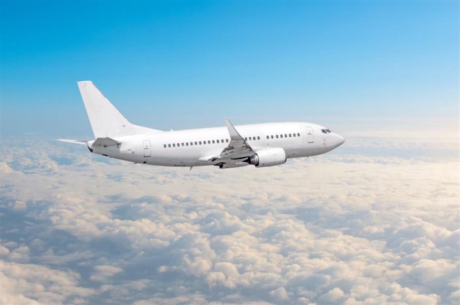 White airplane flies height, flight level high in the sky above the clouds blue sky.