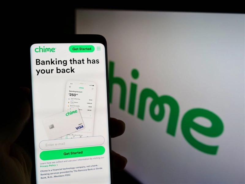 STUTTGART, GERMANY - Aug 18, 2021: Person holding smartphone with website of company Chime Financial Inc. on screen in front of logo. Focus on center of phone display. - Stock Editorial Photography