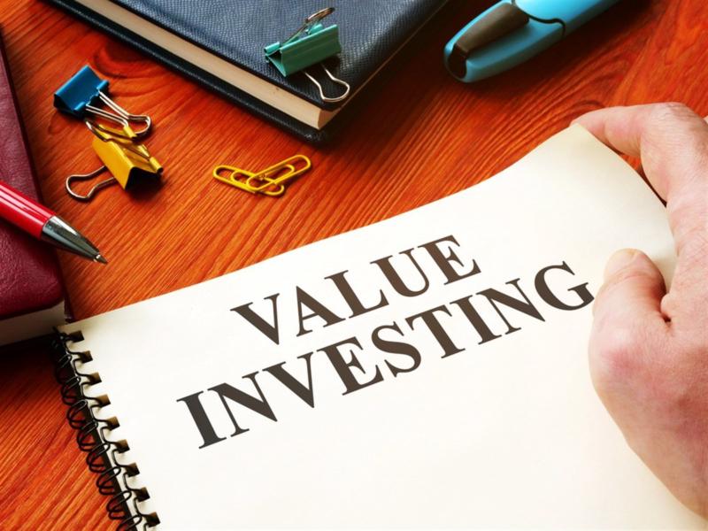 Value Investing on a piece of paper sitting on a desk with accessories