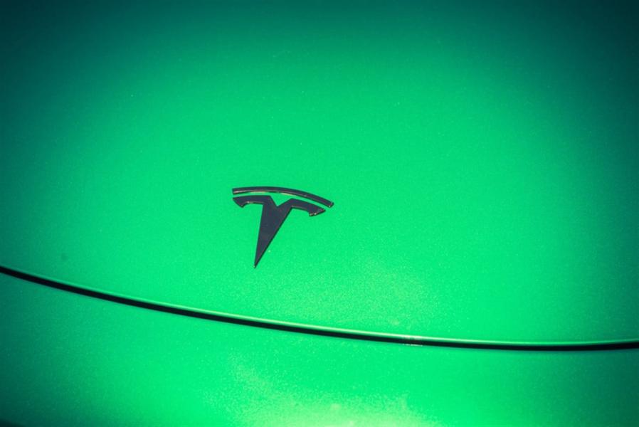 Green car hood cover with Tesla logo close-up — Stock Editorial Photography