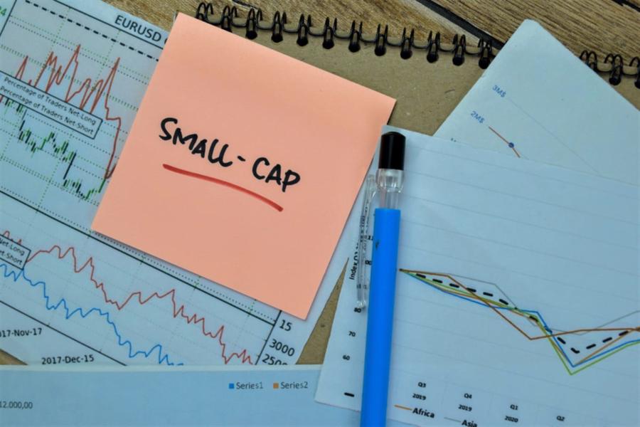 Small-cap write on sticky notes isolated on wooden table.