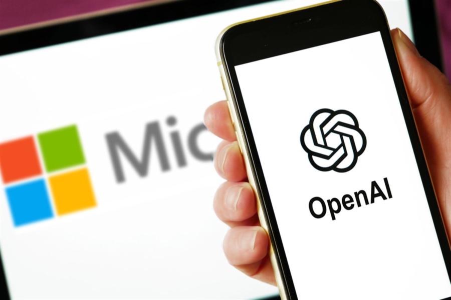 Lviv, Ukraine - 03 11 2023: hand holding smartphone with OPENAI logo on screen and laptop display with MICROSOFT logo on the background. Closeup — Stock Editorial Photography